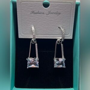 Silver fashion earrings resembling safety pin. Fashion statement New